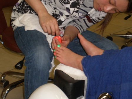 Kasen's toenails being painted green and orange